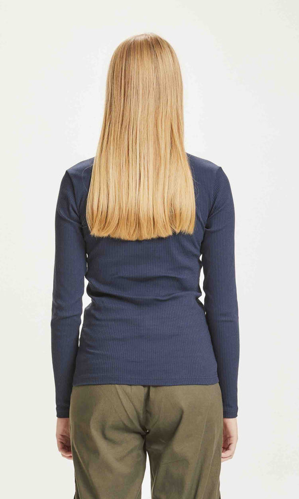 Une femme de dos porte un T shirt à manches longues bleu marine de la marque Knowledge Cotton Apparel.