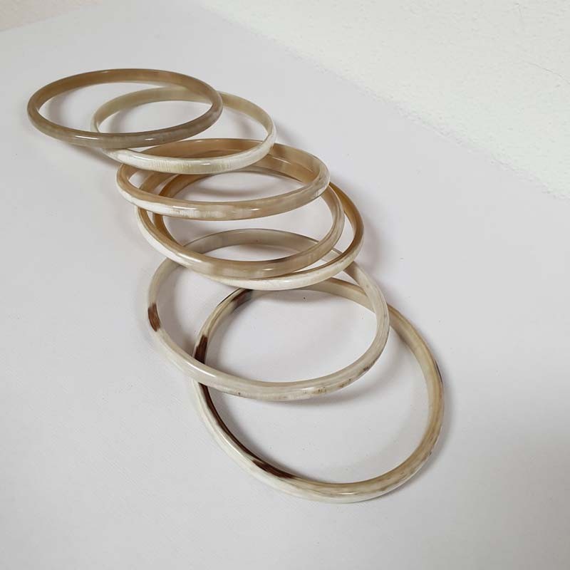 Photo sur fond blanc de bracelets en corne française de couleur claire de 5 mm d'épaisseur et fabriqués en France.