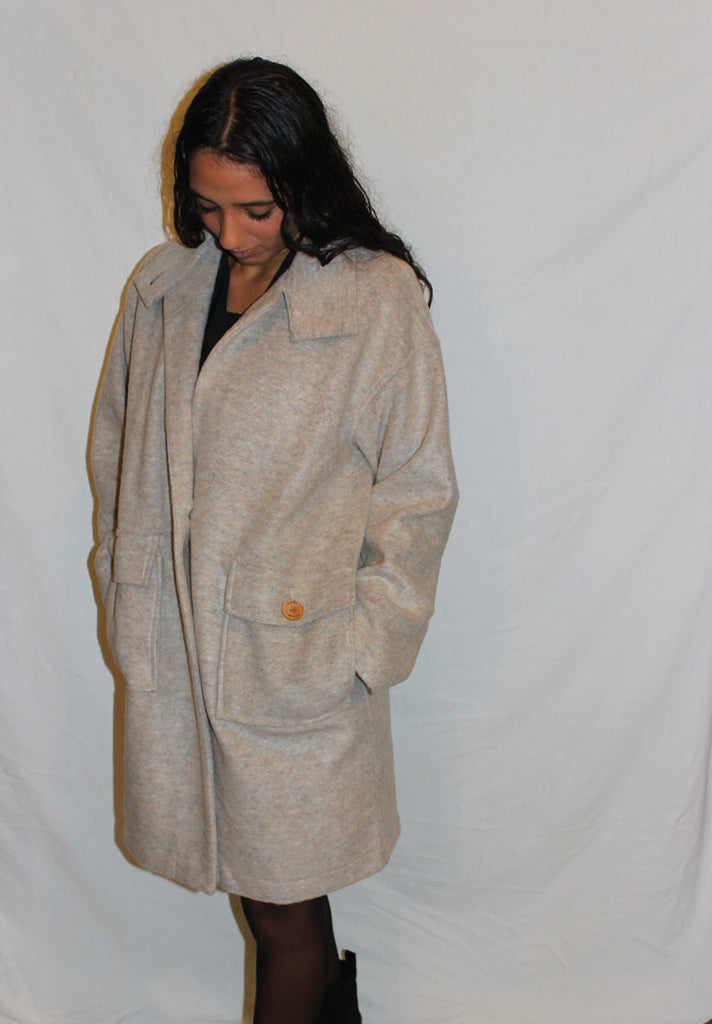 Manteau en laine pour femme, col v. 2 poches plaqués à l'avant. 1 bouton en guise de fermeture. En plusieurs coloris. 100% laine. Fabriqué en Pologne.