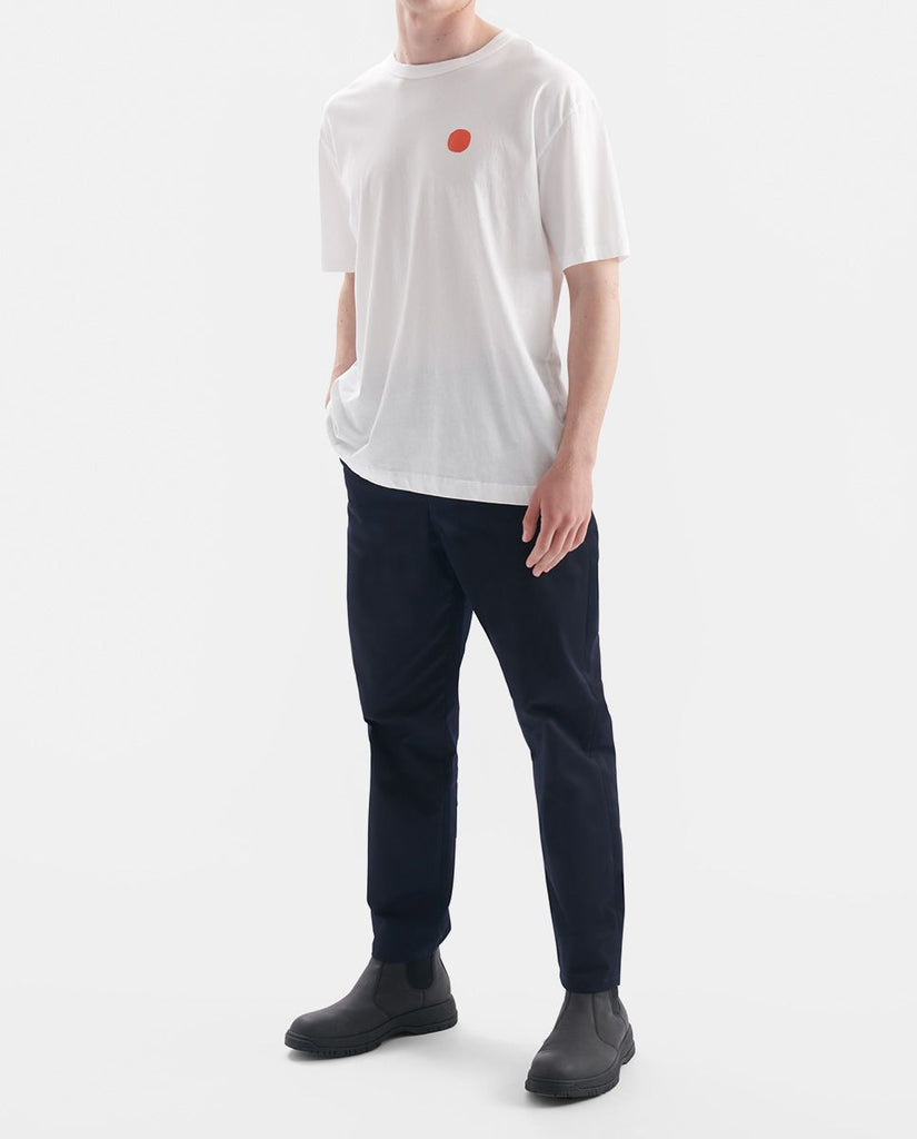 Photo d'un mannequin portant un t shirt en coton bio blanc avec rond rouge sur la poitrine et fabriqué au Portugal.