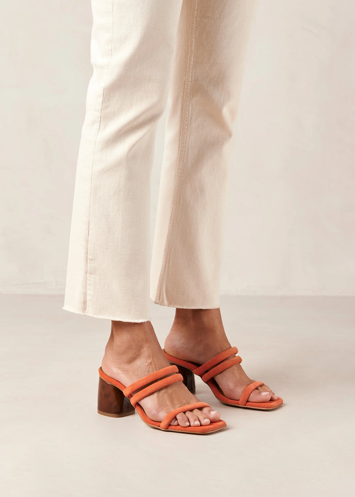 Femme portant des sandales à talons orange.