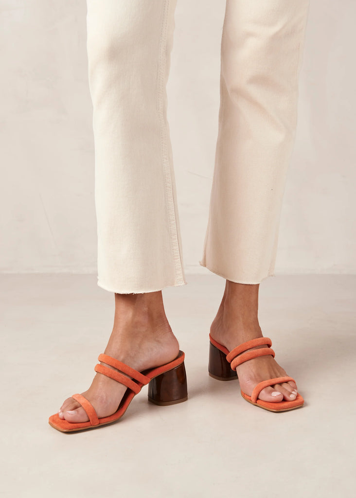 Femme portant des sandales à talons orange.