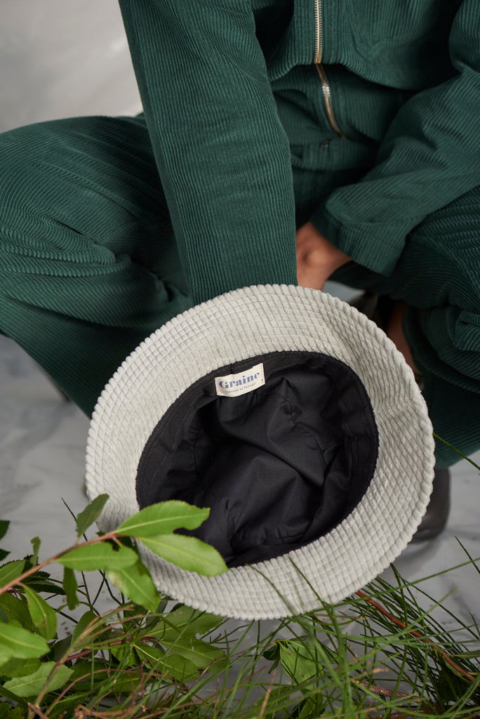 Femme assise avec bob gris en Velour cotelé de la marque Graine fait écologiquement au Portugal.