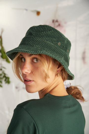 Portrait de femme Blondeau tee-shirt vert qui porte un Bob en Velour cotelé couleur verte.  Production écologique, tissu écologique fait au Portugal de la marque Française Graine.