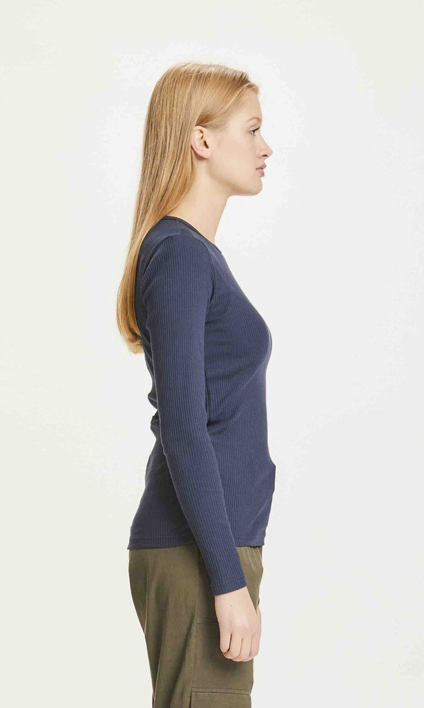 Une femme de côté porte un T shirt à manches longues bleu marine de la marque Knowledge Cotton Apparel.