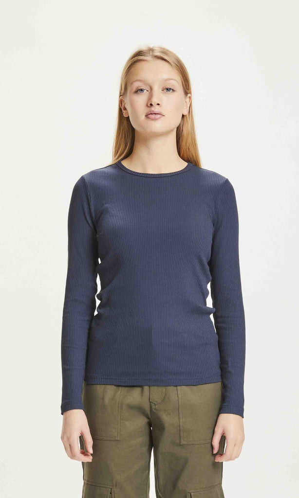 Une femme de face porte un T shirt à manches longues bleu marine de la marque Knowledge Cotton Apparel.