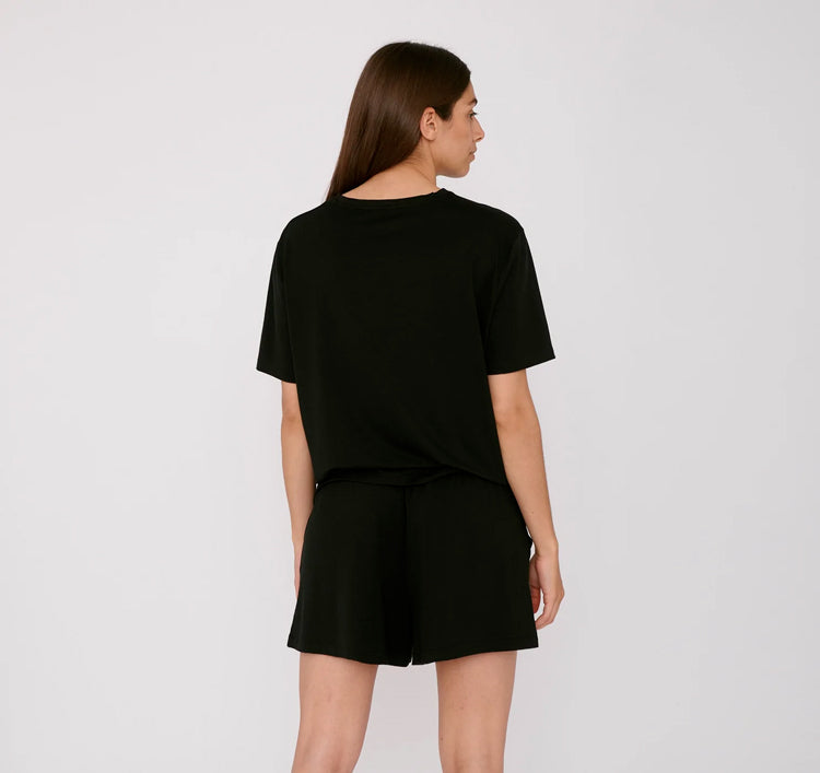 Photo d'un mannequin de dos portant un bas de pyjama court femme noir en tencel de la marque organic basics.