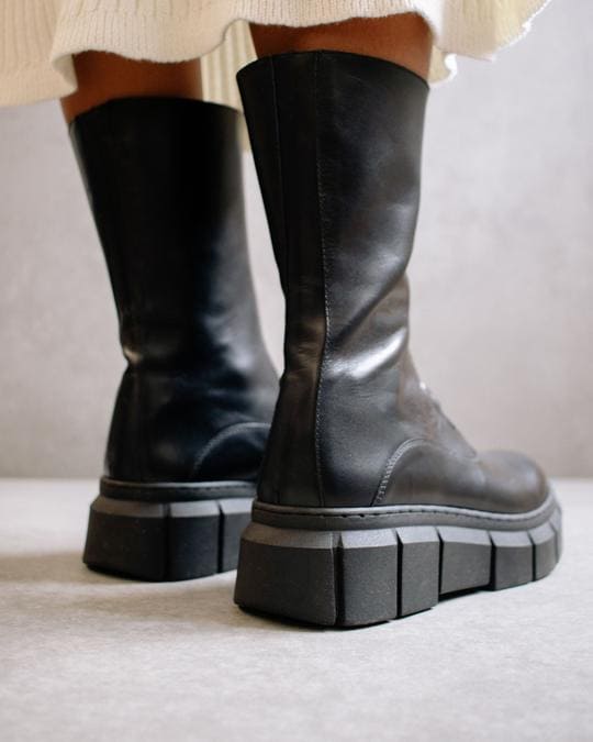 Photo du derrière de bottes avec zip devant noires à plateforme en cuir de la marque espagnole Alohas