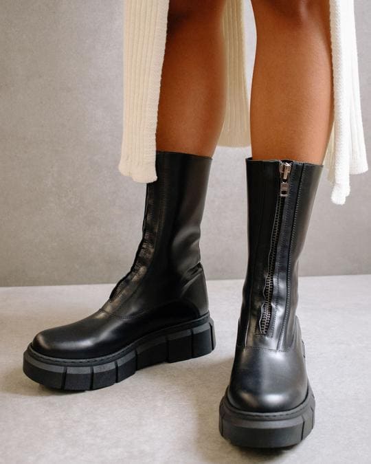 Photo de profil de bottes avec zip devant noires à plateforme arrivant mi-mollet en cuir de la marque espagnole Alohas
