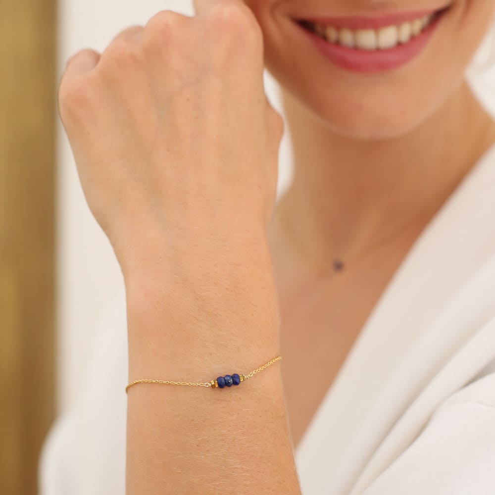Photo d'un mannequin portant un bracelet pierre naturelle lapis lazuli fabriqué en France et en laiton doré à l'or fin. 