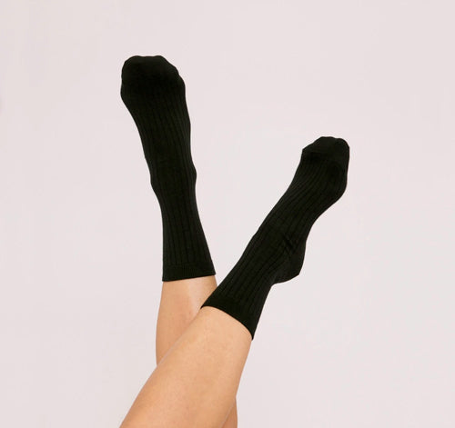 Photo de chaussettes côtelées noires en coton bio portées et fabriquées au Portugal de la marque Organic Basics.