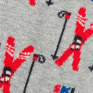 Photo zoomée de chaussettes originales pour homme avec des skis sur fond gris en coton bio de la marque cabaia.