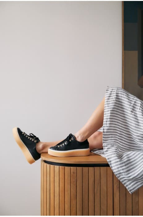 Photo d'une femme portant des chaussures semelle gomme femme en noir de la marque Mint and Rose. 