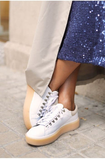 Zoom sur une femme portant des chaussures semelle gomme femme couelur blanc de la marque Mint and Rose. 