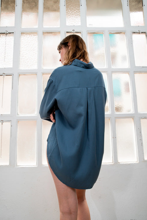 Photo d'un mannequin de dos portant une chemise lyocell femme bleue oversize fabriquée au Portugal de la marque Cossac.