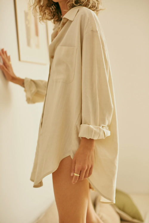 Photo d'un mannequin de profil portant une chemise oversize pour femme couleur écru en lyocell et fabriquée au Portugal.