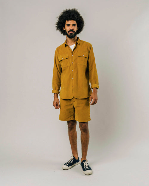 Photo d'un mannequin portant une chemise velours pour homme en jaune moutarde et en coton bio fabriquée au Portugal.