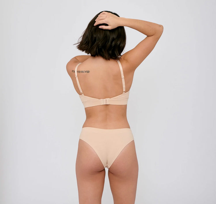 Photo d'un mannequin de dos portant une culotte en coton bio beige de la marque organic basics.