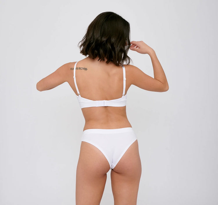 Photo d'un mannequin de dos portant une culotte en coton bio blanc de la marque organic basics.