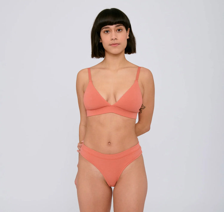 Photo d'un mannequin portant une culotte en coton bio corail de la marque organic basics.