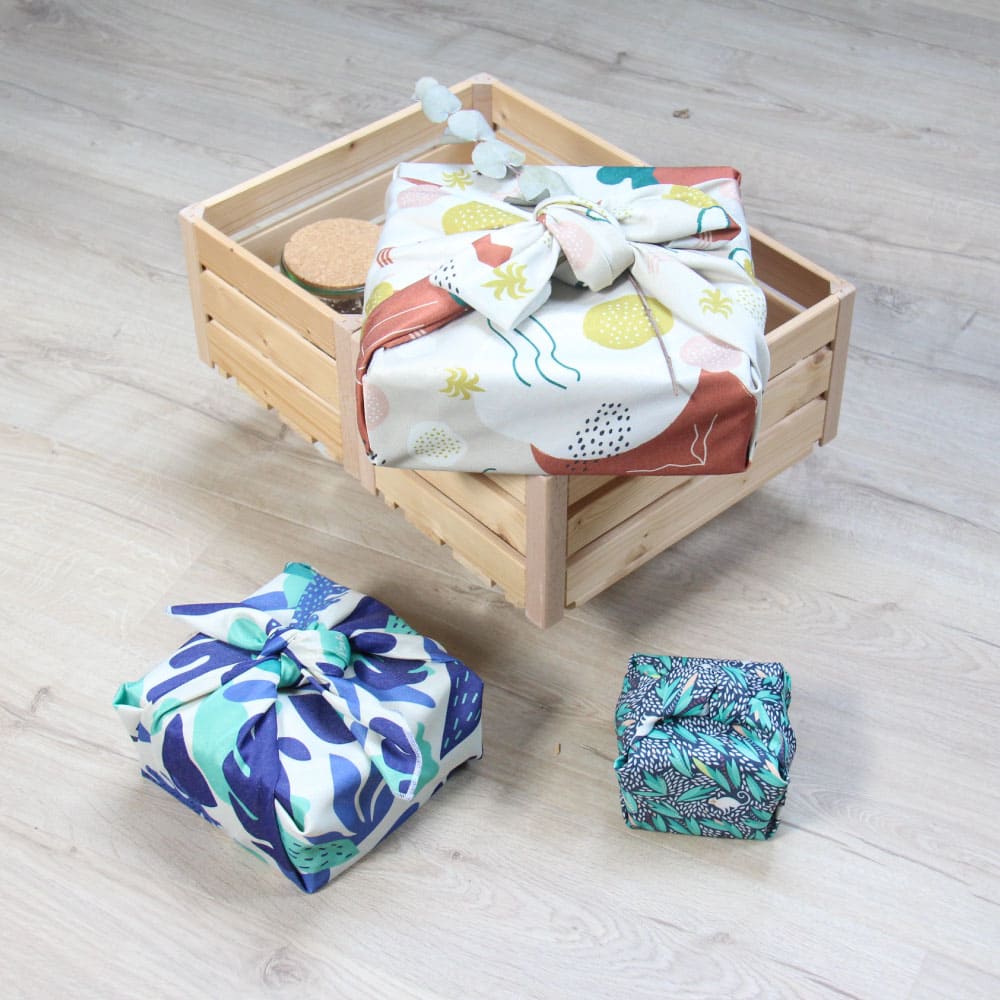 Photo de trois paquets emballés dans un tissu furoshiki réutilisable de la marque Paké.