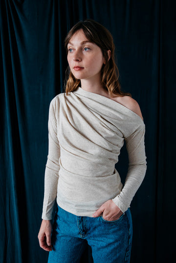 Photo d'un mannequin portant un haut épaule dénudée écru en matières recyclées de la marque Cossac.