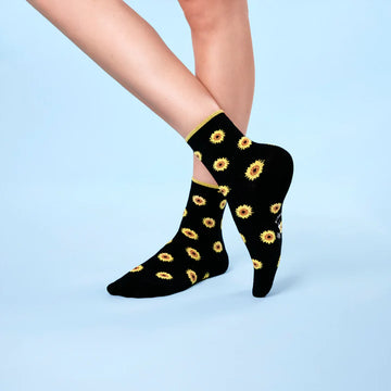 Femme qui porte des chaussettes noires avec des tournesols