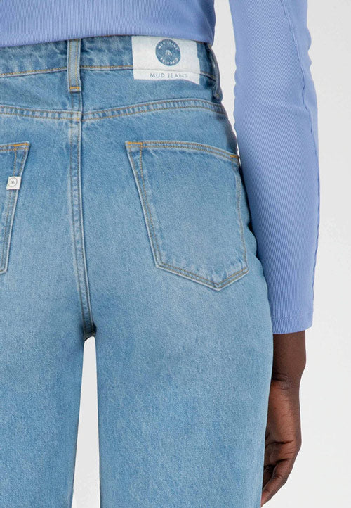 Photo zoomée sur le poche arrière d'un jean jambes larges couleur bleu ciel en coton bio et recyclé et fabriqué en Tunisie.