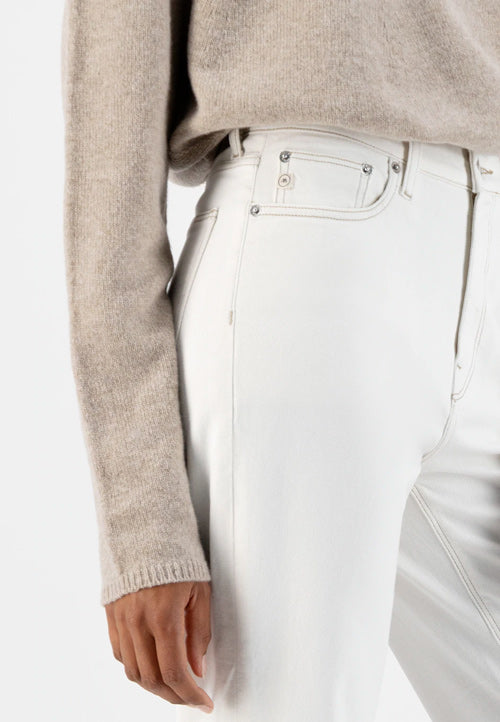 Photo zoomée sur les poches de devant d'un jean mom taille haute couleur écru en coton bio et recyclé fabriqué en Tunisie.