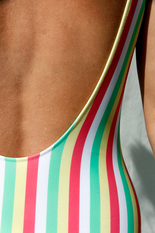 Photo zoomée sur le décolleté du dos d'un maillot de bain rayé multicolore en nylon recyclé et fabriqué en Italie.