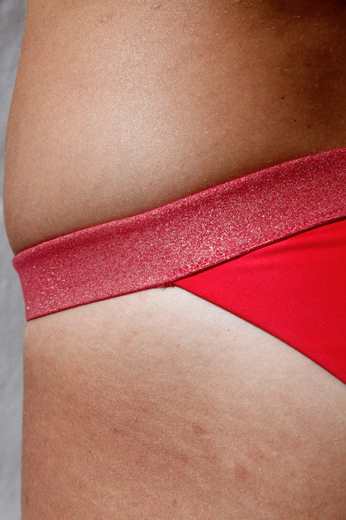 Photo zoomée sur le bas d'un maillot de bain sans armature rose en nylon recyclé et fabriqué en Italie.