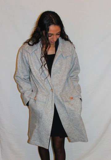 Manteau en laine pour femme, col v. 2 poches plaqués à l'avant. 1 bouton en guise de fermeture. En plusieurs coloris. 100% laine. Fabriqué en Pologne.