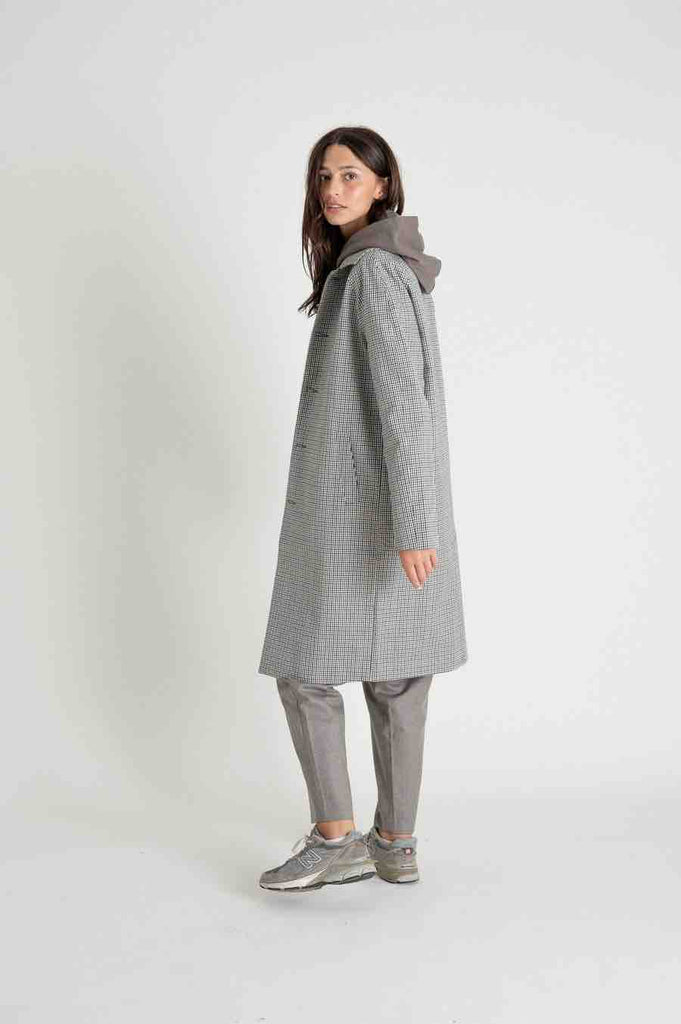 Photo d'un mannequin de profil portant un manteau mi saison mixte à carreaux en coton bio de chez Noyoco.