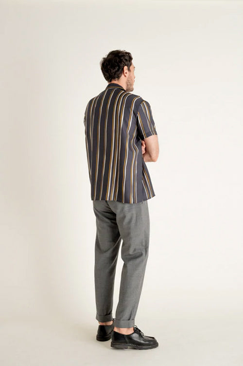Un homme de dos porte un pantalon à pince gris en laine vierge de la marque Noyoco.