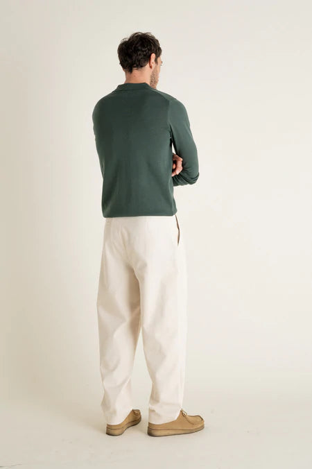 Photo d'un mannequin de dos portant un pantalon carotte taille haute écru en coton bio de la marque Noyoco.