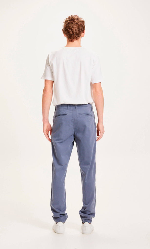 Photo d'un mannequin de dos portant un pantalon chino droit pour homme bleu gris en coton bio de la marque knowledge cotton apparel.
