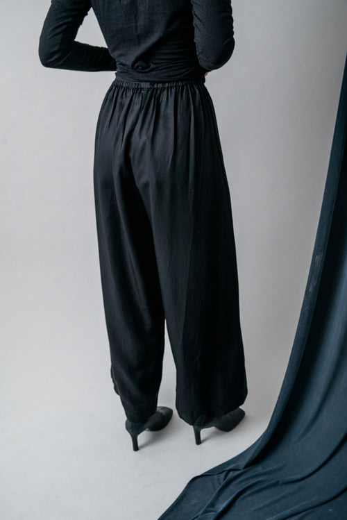 Photo d'un mannequin de dos portant un pantalon large fluide femme noir en lyocell fabriqué au Portugal.