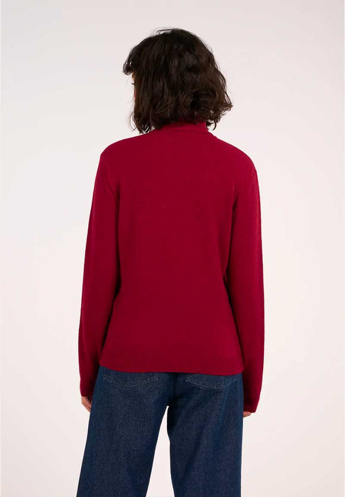 Mannequin femme portant un pull à col roulé rouge