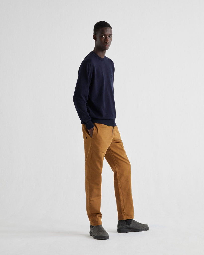 Photo d'un mannequin de plein pied portant un pull col rond bleu marine pour homme en coton bio et coton recyclé fabriqué en Espagne.