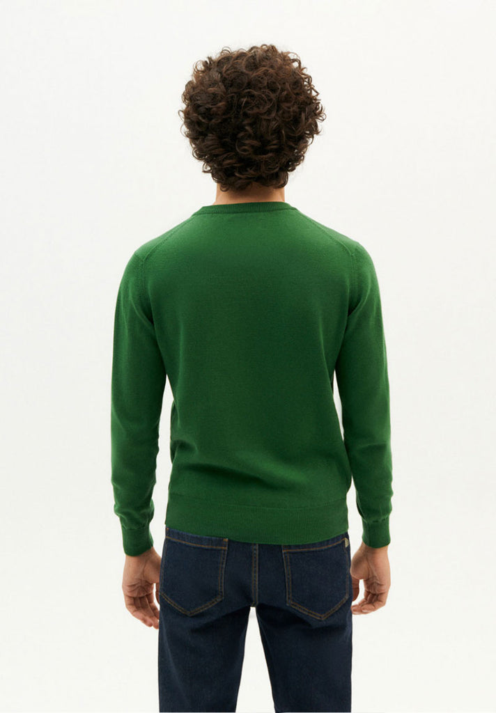 Photo zoomée d'un mannequin portant un pull col rond vert pour homme en coton bio et coton recyclé fabriqué en Espagne.