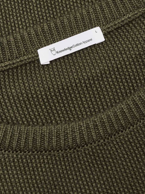 Photo zoomée du col d'un pull en coton bio pour homme couleur vert sapin de la marque knowledge cotton apparel.