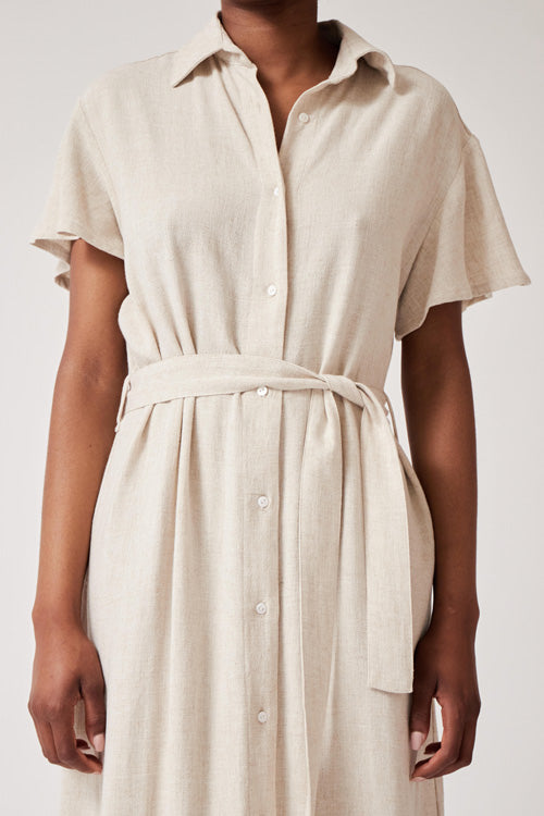 Photo zoomée sur une robe chemise ceinturée couleur crème en rayonne et lin et fabriquée en Espagne.