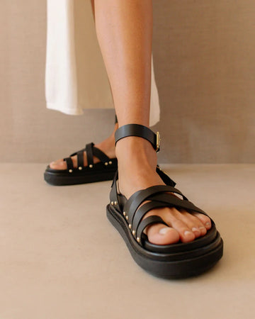 Photo d'une mannequin portant des sandales en cuir végétal noires fabriquées en Espagne par Alohas.