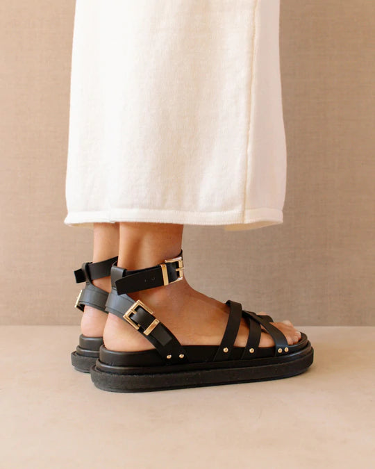 Phot d'une mannequin portant des sandales en cuir végétal noires fabriquées en Espagne par Alohas.