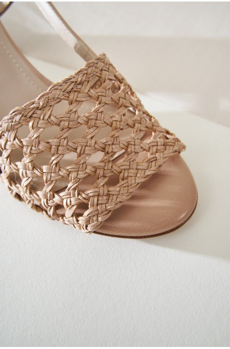 Photo zoomée sur le tressage de sandales tressées beiges en cuir et fabriquées en Espagne.