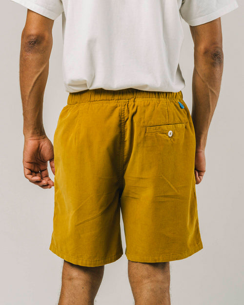 Photo d'un mannequin de dos portant un short en velours pour homme moutarde en coton bio fabriqué au Portugal.