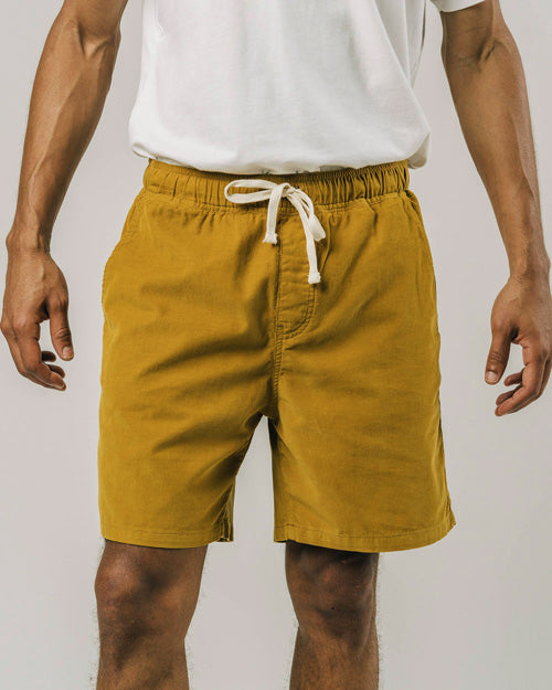 Photo d'un mannequin portant un short en velours pour homme moutarde en coton bio fabriqué au Portugal.