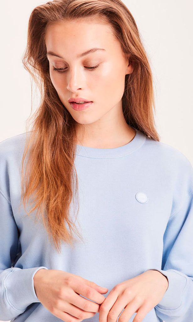 Photo d'un mannequin de face portant un sweat bleu ciel en coton bio de la marque knowledge cotton apparel.