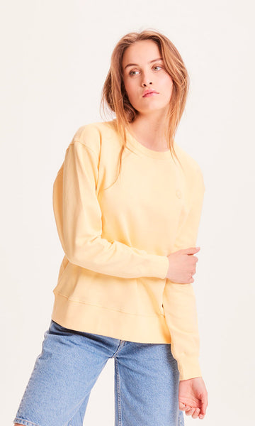Photo d'un mannequin portant un sweat jaune pastel pour femme en coton bio de la marque knowledge cotton apparel.