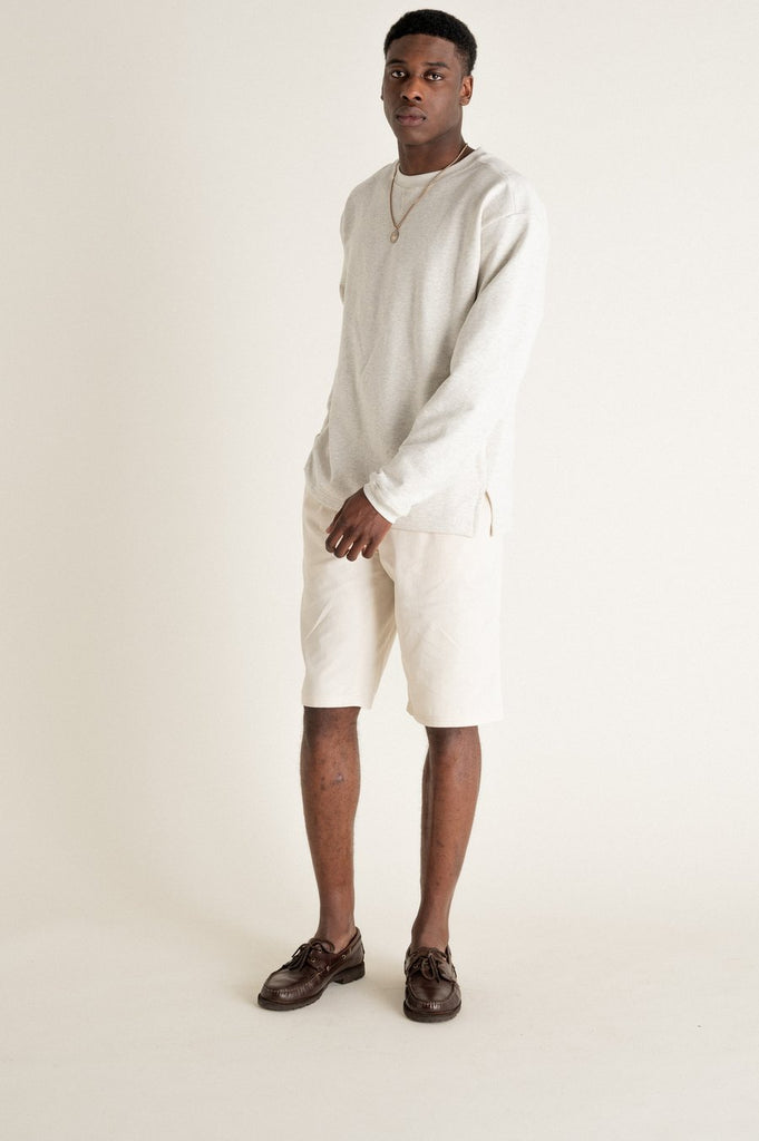 Un homme de côté porte un sweat gris en coton biologique de la marque Noyoco.